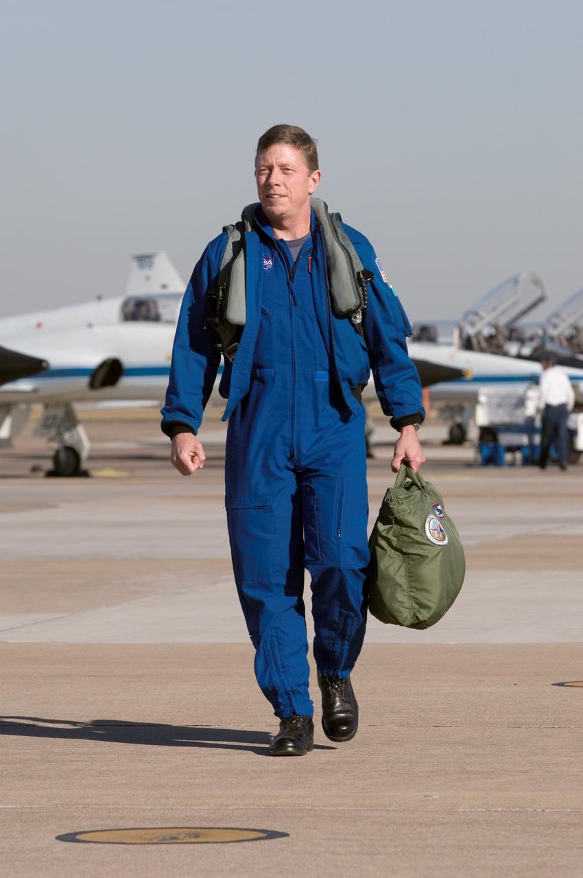 JSC2005-E-45666 (29 November 2005) --- Astronaut Michael E. Fossum, STS-121 mission specialist, attired in flight gear, walks near the flight line of the NASA T-38 trainer jets at Ellington Field near Johnson Space Center.