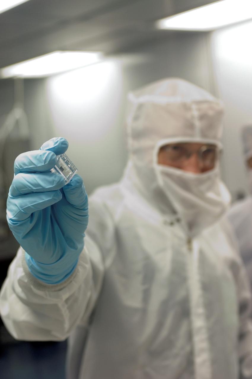 French Scientist Francois Robert holds up a sample obtained from the Stardust Mission for the camera in the Stardust Laboratory in Building 31, Johnson Space Center (JSC).