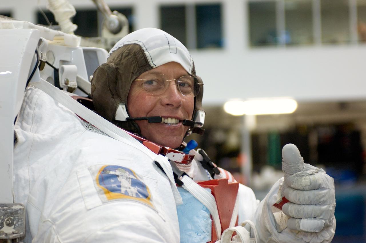 JSC2006-E-20866 (1 June 2006) --- Astronaut Michael E. Fossum, STS-121 mission specialist, dons a training version of his Extravehicular Mobility Unit (EMU) spacesuit prior to being submerged in the waters of the Neutral Buoyancy Laboratory (NBL) near Johnson Space Center.