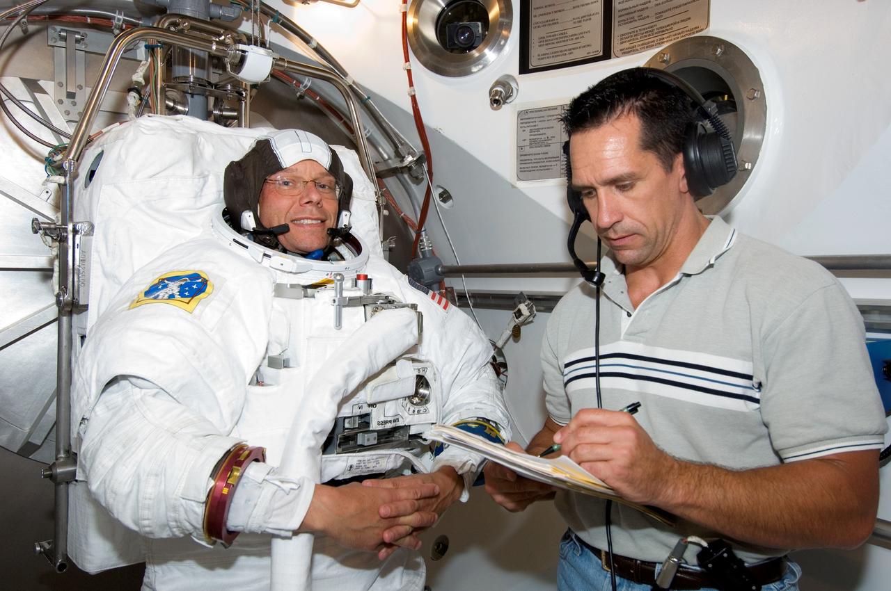 JSC2006-E-31759 (27 July 2006) --- European Space Agency (ESA) astronaut Christer Fuglesang, STS-116 mission specialist, participates in an Extravehicular Mobility Unit (EMU) spacesuit fit check in the Space Station Airlock Test Article (SSATA) in the Crew Systems Laboratory at the Johnson Space Center. Astronaut William A. Oefelein, pilot, assisted Fuglesang.