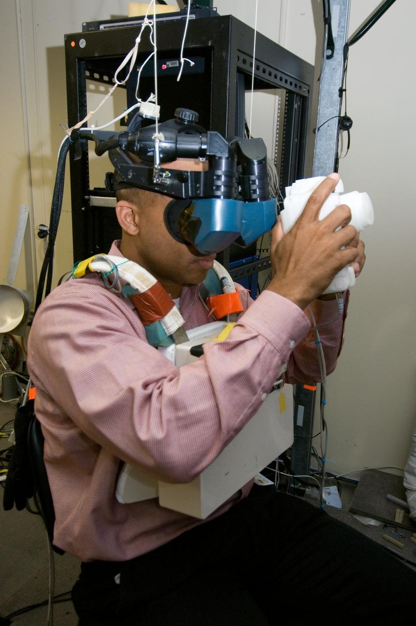 JSC2006-E-33306 (7 Aug. 2006) --- Astronaut Robert L. Curbeam, STS-116 mission specialist, uses virtual reality hardware in the Space Vehicle Mockup Facility at the Johnson Space Center to rehearse some of his duties on the upcoming mission to the International Space Station. This type of virtual reality training allows the astronauts to wear a helmet and special gloves while looking at computer displays simulating actual movements around the various locations on the station hardware with which they will be working.