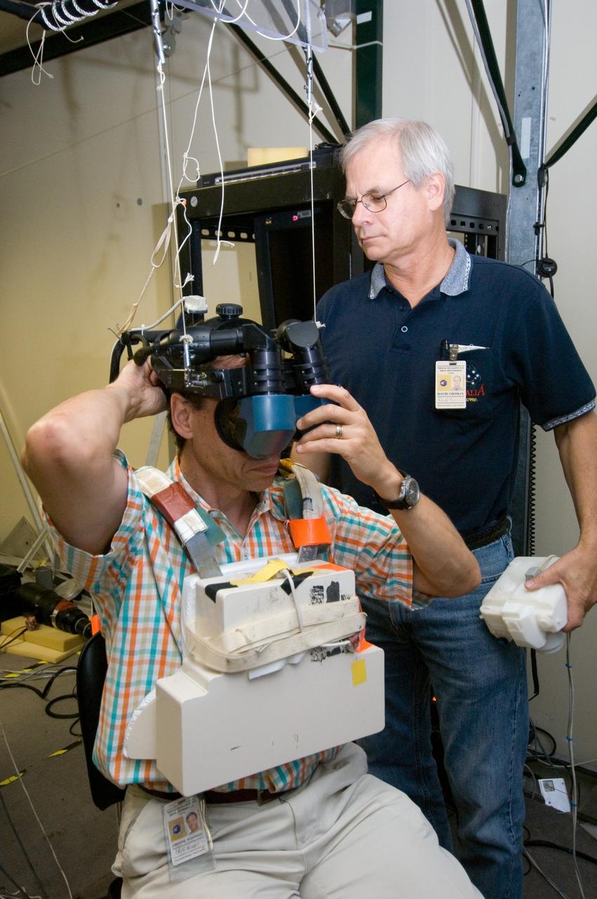 JSC2006-E-33308 (7 Aug. 2006) --- European Space Agency (ESA) astronaut Christer Fuglesang, STS-116 mission specialist, uses virtual reality hardware in the Space Vehicle Mockup Facility at the Johnson Space Center to rehearse some of his duties on the upcoming mission to the International Space Station. This type of virtual reality training allows the astronauts to wear a helmet and special gloves while looking at computer displays simulating actual movements around the various locations on the station hardware with which they will be working. David J. Homan assisted Fuglesang.