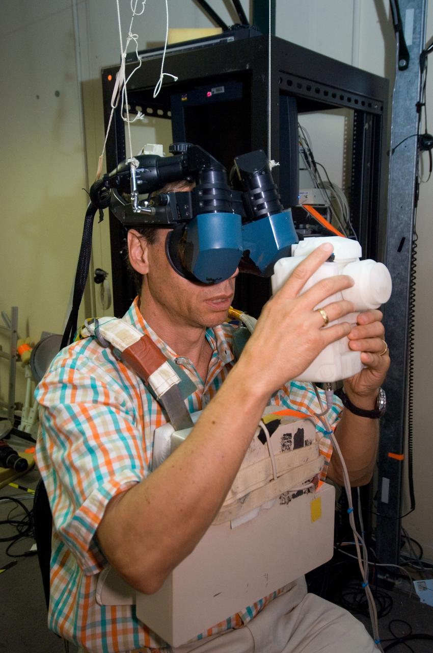 JSC2006-E-33309 (7 Aug. 2006) --- European Space Agency (ESA) astronaut Christer Fuglesang, STS-116 mission specialist, uses virtual reality hardware in the Space Vehicle Mockup Facility at the Johnson Space Center to rehearse some of his duties on the upcoming mission to the International Space Station. This type of virtual reality training allows the astronauts to wear a helmet and special gloves while looking at computer displays simulating actual movements around the various locations on the station hardware with which they will be working.