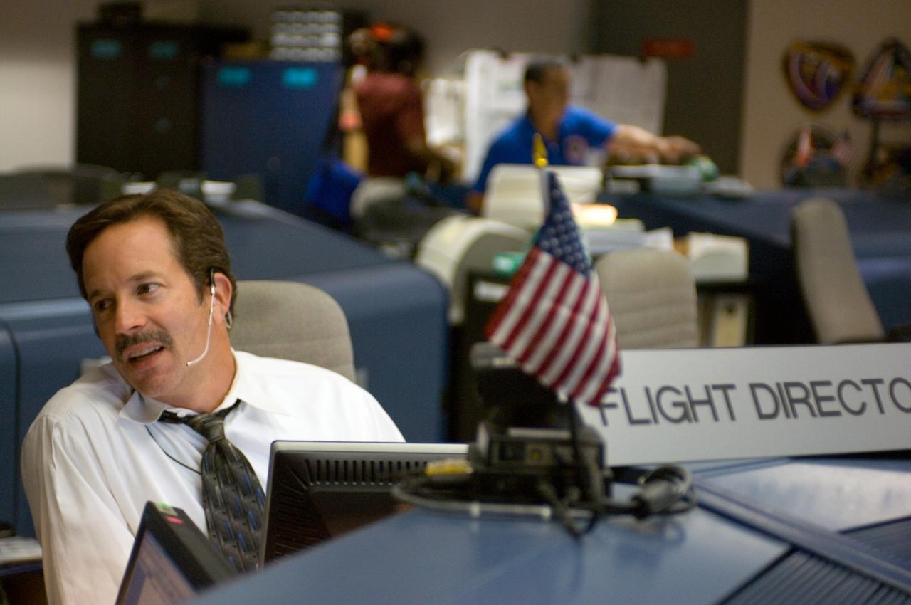 JSC2006-E-38926 (31 Aug. 2006) --- Flight director Rick LaBrode discusses Expedition 13 mission activities with another flight controller (out of frame) in the Station (Blue) Flight Control Room in Houston's Mission Control Center.
