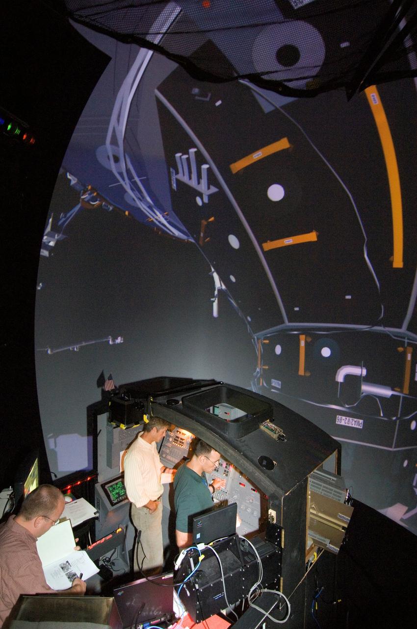 JSC2006-E-39171 (1 Sept. 2006) --- Astronauts Steven R. Swanson (center) and Lee J. Archambault (right), STS-117 mission specialist and pilot, respectively, participate in an exercise in the systems engineering simulator at NASA's Johnson Space Center. The facility includes moving scenes of full-sized International Space Station components over a simulated Earth.