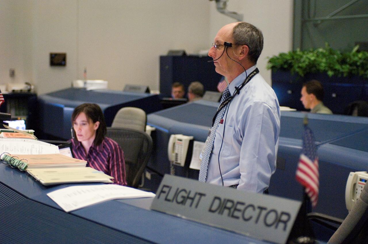 JSC2006-E-39881 (10 Sept. 2006) --- In the Shuttle (White) Flight Control Room of Houston's Mission Control Center, flight director Paul Dye (right) and spacecraft communicator (CAPCOM) Megan McArthur monitor data during the STS-115 inspection of the wings' leading edge and nose cap of the Space Shuttle Atlantis.