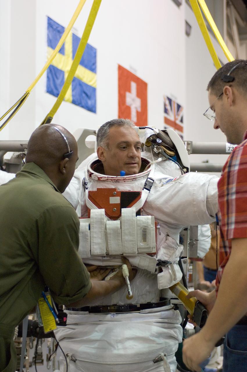 JSC2006-E-44632 (16 Oct. 2006) --- Astronaut John D. (Danny) Olivas, STS-117 mission specialist, dons a training version of the Extravehicular Mobility Unit (EMU) spacesuit prior to being submerged in the waters of the Neutral Buoyancy Laboratory (NBL) near Johnson Space Center. Suit technicians assisted Olivas.