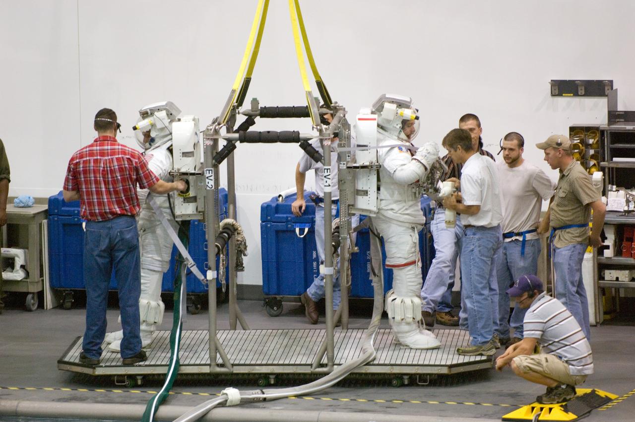 JSC2006-E-44663 (16 Oct. 2006) --- Astronauts John D. (Danny) Olivas and James F. Reilly II, both STS-117 mission specialists, are about to be submerged in the waters of the Neutral Buoyancy Laboratory (NBL) near Johnson Space Center. Olivas and Reilly are attired in training versions of the Extravehicular Mobility Unit (EMU) spacesuit.