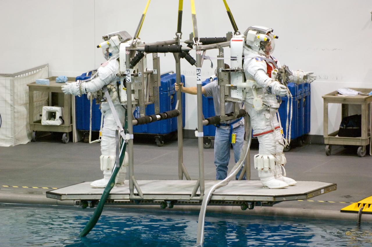JSC2006-E-44664 (16 Oct. 2006) --- Astronauts John D. (Danny) Olivas and James F. Reilly II, both STS-117 mission specialists, are about to be submerged in the waters of the Neutral Buoyancy Laboratory (NBL) near Johnson Space Center. Olivas and Reilly are attired in training versions of the Extravehicular Mobility Unit (EMU) spacesuit.
