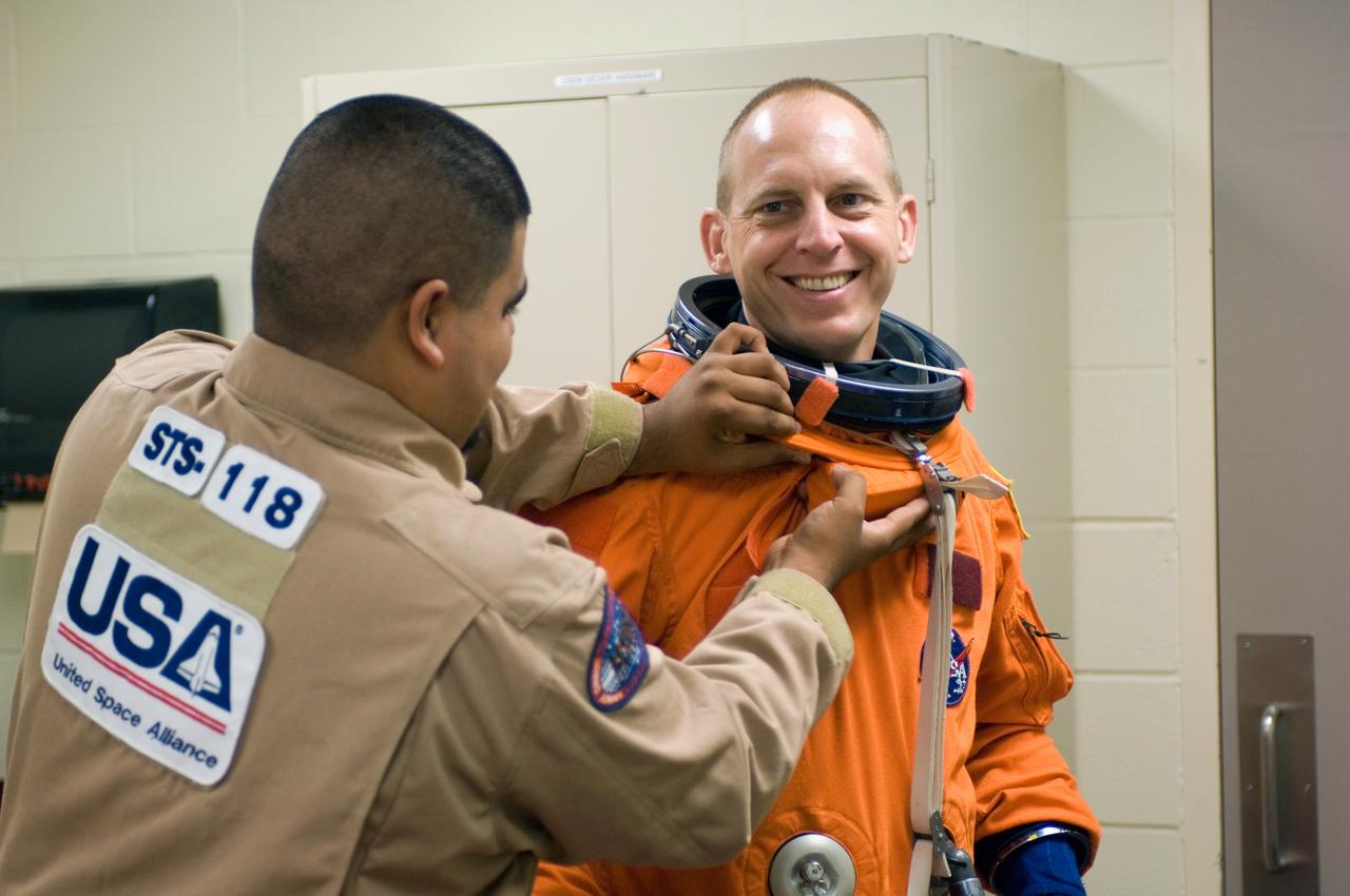 JSC2006-E-45151 (18 Oct. 2006) --- Astronaut Clayton C. Anderson, Expedition 15 NASA space station science officer and flight engineer, dons a training version of his shuttle launch and entry suit, prior to the start of a mission training session in the Space Vehicle Mockup Facility at Johnson Space Center. United Space Alliance (USA) suit technician Joe Alvarado assisted Anderson.