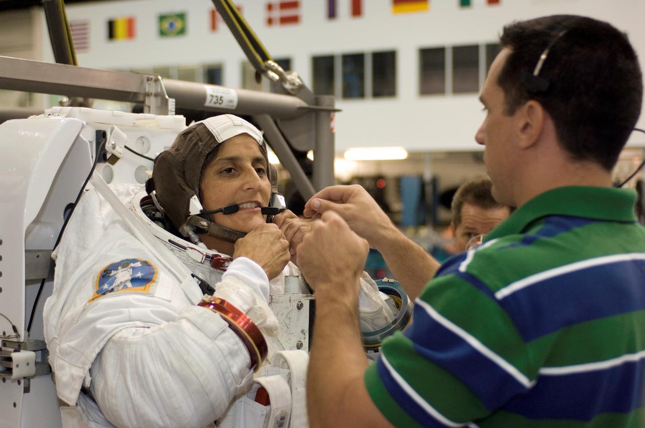 JSC2006-E-46464 (25 Oct. 2006) --- Astronaut Sunita L. Williams, Expedition 14 flight engineer, dons a training version of the Extravehicular Mobility Unit (EMU) spacesuit prior to being submerged in the waters of the Neutral Buoyancy Laboratory (NBL) near Johnson Space Center. Astronaut William A. (Bill) Oefelein, STS-116 pilot, assisted Williams.