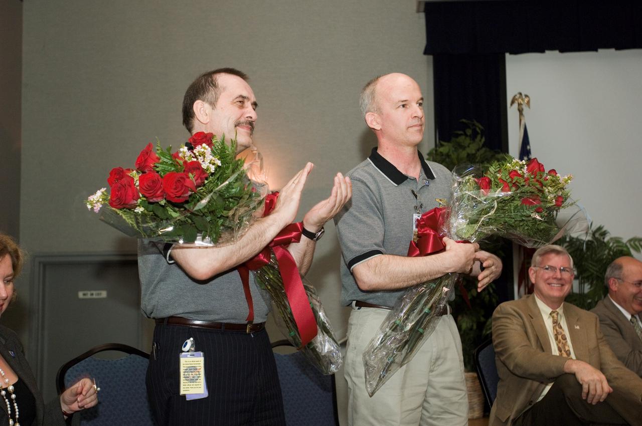 JSC2006-E-46706 (26 Oct. 2006) --- Cosmonaut Pavel V. Vinogradov (left), Expedition 13 commander representing Russia's Federal Space Agency, and astronaut Jeffrey N. Williams, NASA space station science officer and flight engineer, are pictured with floral arrangements in the ballroom of the Gilruth Center at Johnson Space Center (JSC) during the Expedition 13 welcome home ceremony. JSC Director Michael L. Coats is seated at right.