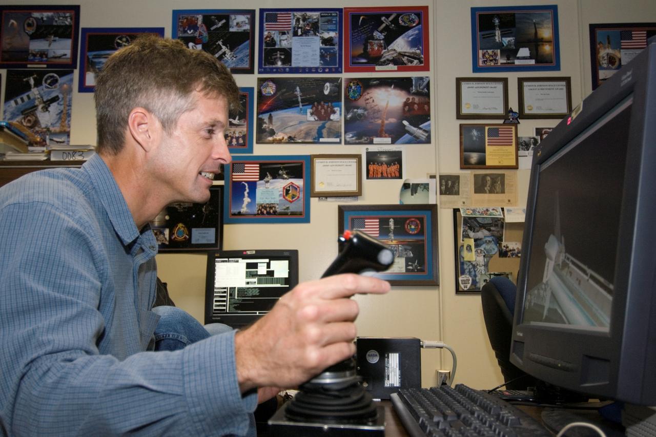 JSC2006-E-47612 (1 Nov. 2006) --- Astronaut Steven R. Swanson, STS-117 mission specialist, uses the virtual reality lab at Johnson Space Center to train for his duties aboard the space shuttle and space station. This type of computer interface, paired with virtual reality training hardware and software, helps to prepare the entire team for dealing with space station elements.