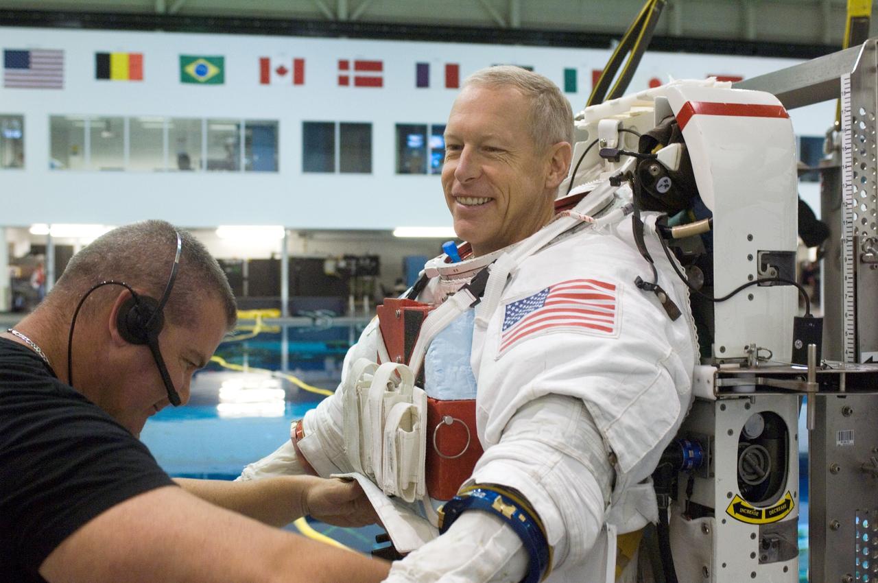 JSC2006-E-48960 (9 Nov. 2006) --- Astronaut Patrick G. Forrester, STS-117 mission specialist, dons a training version of the Extravehicular Mobility Unit (EMU) spacesuit prior to being submerged in the waters of the Neutral Buoyancy Laboratory (NBL) near Johnson Space Center. A suit technician assisted Forrester.