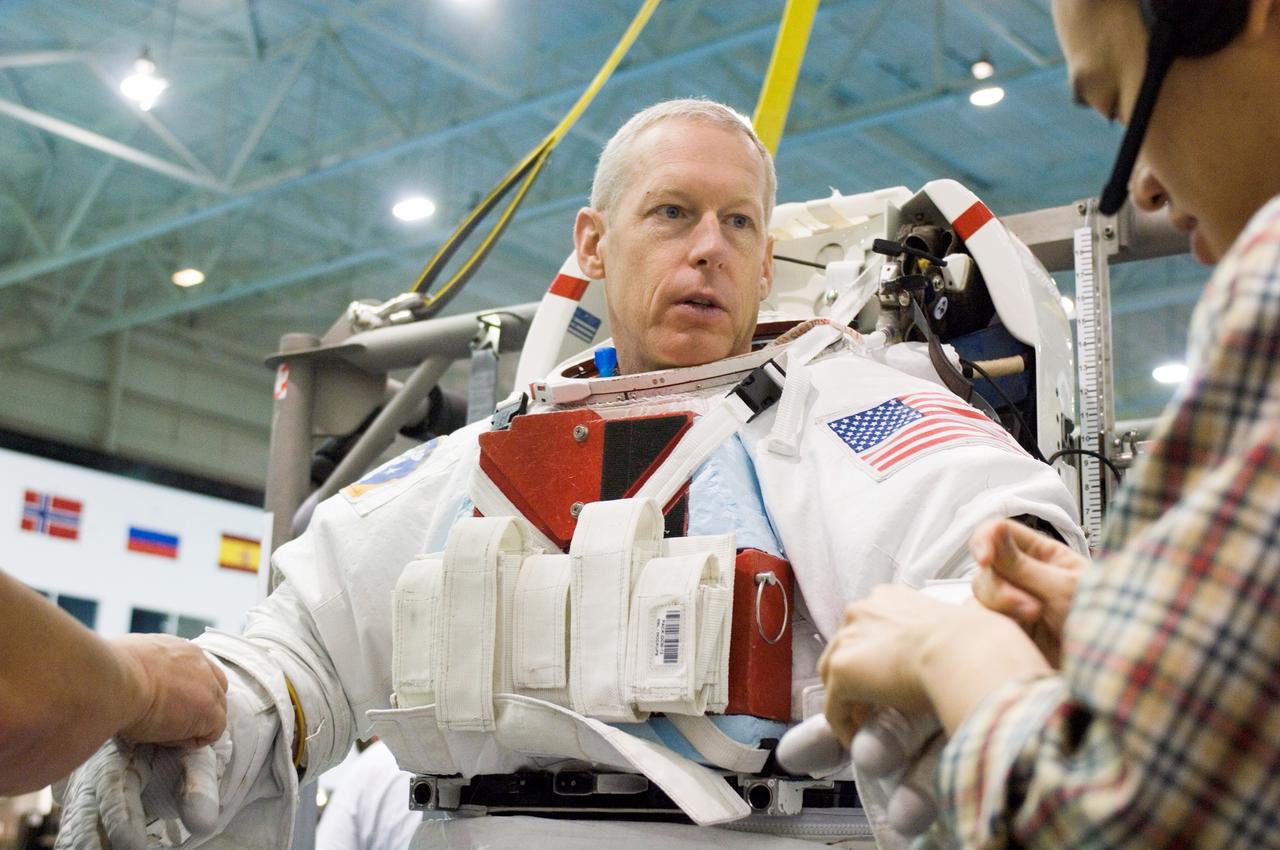 JSC2006-E-48964 (9 Nov. 2006) --- Astronaut Patrick G. Forrester, STS-117 mission specialist, dons a training version of the Extravehicular Mobility Unit (EMU) spacesuit prior to being submerged in the waters of the Neutral Buoyancy Laboratory (NBL) near Johnson Space Center. Suit technicians assisted Forrester.