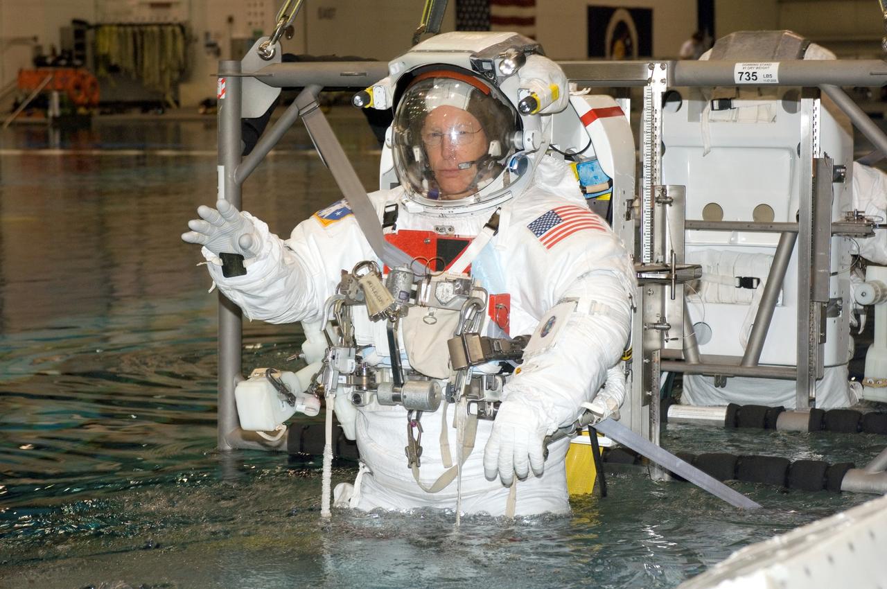 JSC2006-E-48972 (9 Nov. 2006) --- Astronauts Patrick G. Forrester and Steven R. Swanson (partially obscured), both STS-117 mission specialists, are about to be submerged in the waters of the Neutral Buoyancy Laboratory (NBL) near Johnson Space Center. Forrester and Swanson are attired in training versions of the Extravehicular Mobility Unit (EMU) spacesuit. SCUBA-equipped divers (out of frame) are in the water to assist the crewmembers in their rehearsal, intended to help prepare them for work on the exterior of the International Space Station.