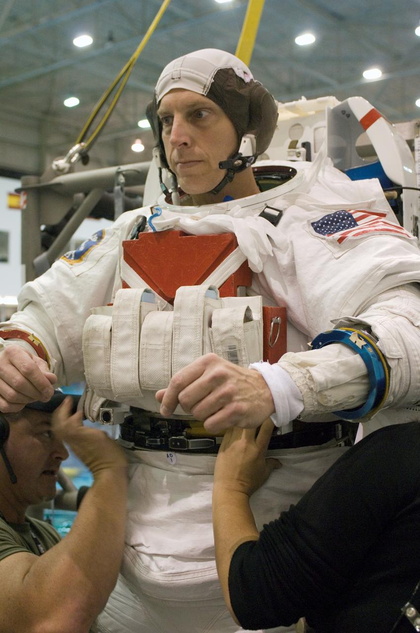 JSC2006-E-49770 (16 Nov. 2006) --- Astronaut Clayton C. Anderson, Expedition 15 flight engineer, dons a training version of the Extravehicular Mobility Unit (EMU) space suit prior to being submerged in the waters of the Neutral Buoyancy Laboratory (NBL) near the Johnson Space Center. Suit technicians assisted Anderson.