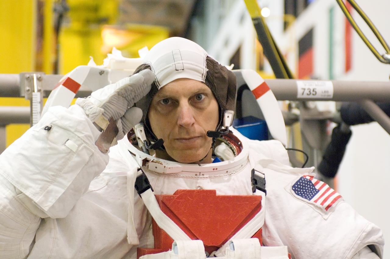 JSC2006-E-49773 (16 Nov. 2006) --- Astronaut Clayton C. Anderson, Expedition 15 flight engineer, salutes as he dons a training version of the Extravehicular Mobility Unit (EMU) space suit prior to being submerged in the waters of the Neutral Buoyancy Laboratory (NBL) near the Johnson Space Center.