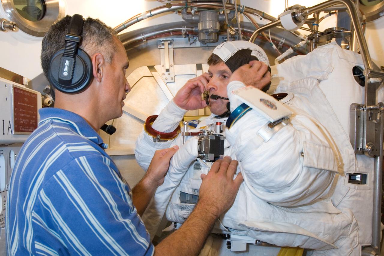 JSC2006-E-51589 (30 Nov. 2006) --- Astronaut Steven R. Swanson, STS-117 mission specialist, participates in an Extravehicular Mobility Unit (EMU) spacesuit fit check in the Space Station Airlock Test Article (SSATA) in the Crew Systems Laboratory at the Johnson Space Center. Astronaut John D. (Danny) Olivas, mission specialist, assisted Swanson.