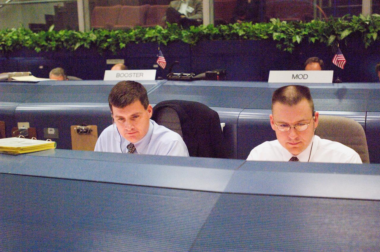 JSC2006-E-53532 (9 Dec. 2006) --- Steve Stich (left), ascent flight director for STS-116, and Norm Knight, entry flight director, keep a close watch on their consoles showing activities at the Kennedy Space Center as preparations are underway for launch of the flight.