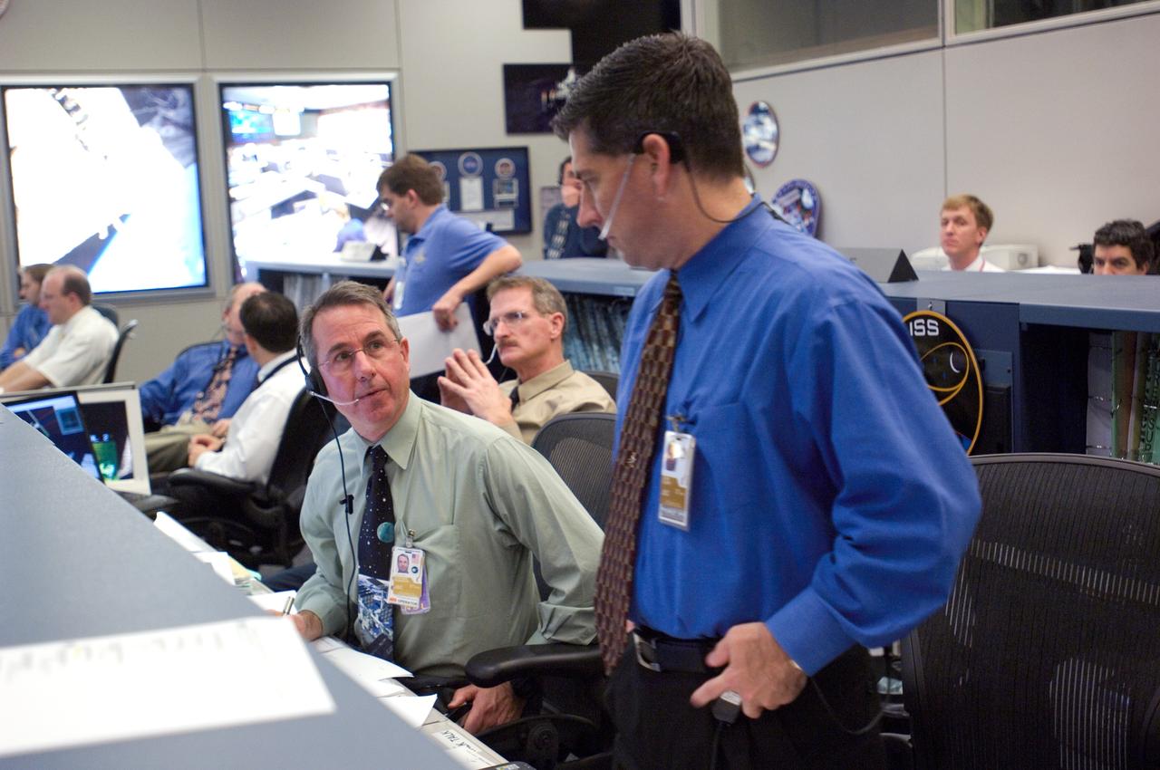 JSC2006-E-54436 (18 Dec. 2006) --- ISS lead flight director John Curry (right) and astronaut Stephen K. Robinson, at the CAPCOM console, represent part of the busy ground support effort for the add-on spacewalk by the STS-116 crew. Astronaut Joseph R. Tanner, who like Robinson is a veteran of multiple space walks, assisted with CAPCOM duties.  While flight controllers in this space station flight control room were busy supporting the spacewalk, so were their counterparts in the space shuttle flight control room, not far away in the Johnson Space Center's Mission Control Center.
