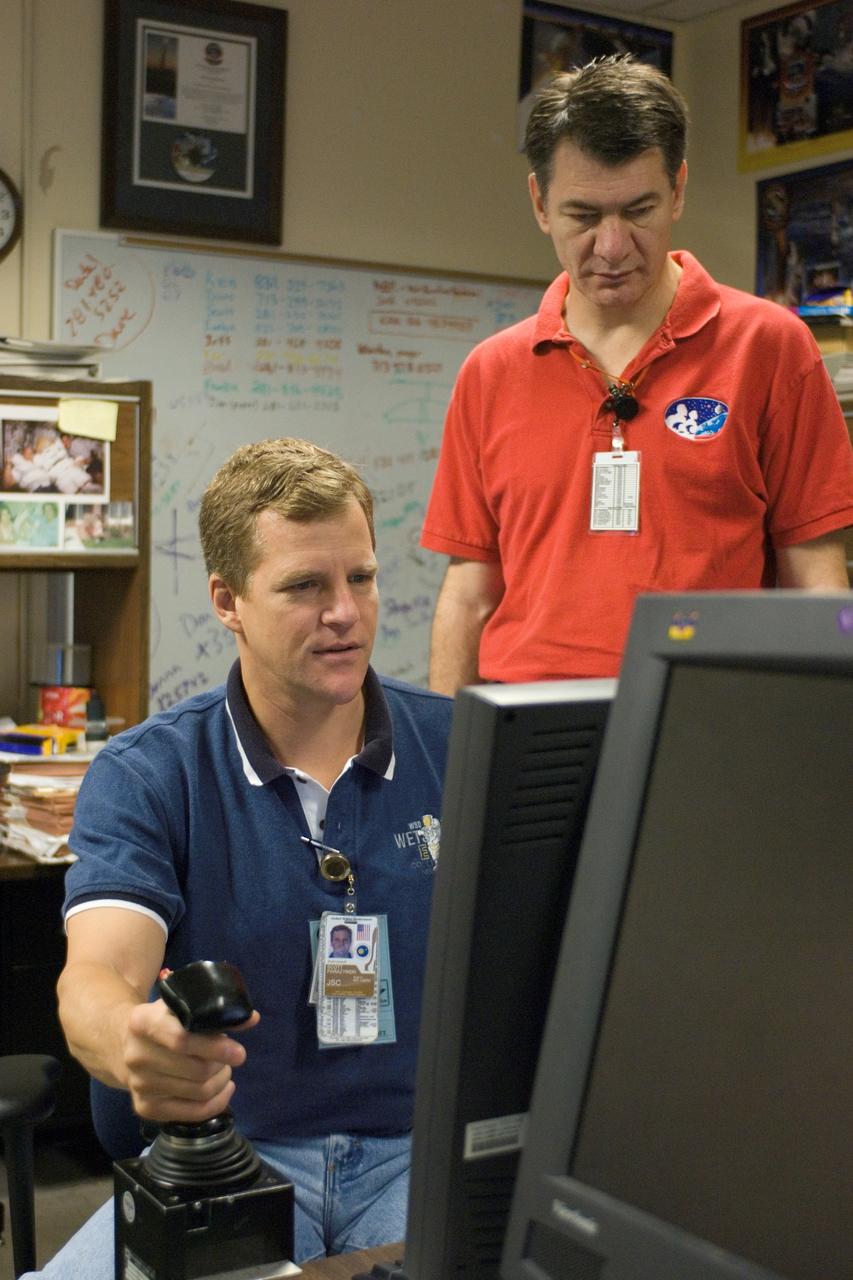 JSC2007-E-41528 (9 Aug. 2007) --- Astronauts Scott E. Parazynski (seated) and European Space Agency's (ESA) Paolo Nespoli, both STS-120 mission specialists, use the virtual reality lab at Johnson Space Center to train for their duties aboard the space shuttle and space station. This type of computer interface, paired with virtual reality training hardware and software, helps to prepare the entire team for dealing with space station elements.
