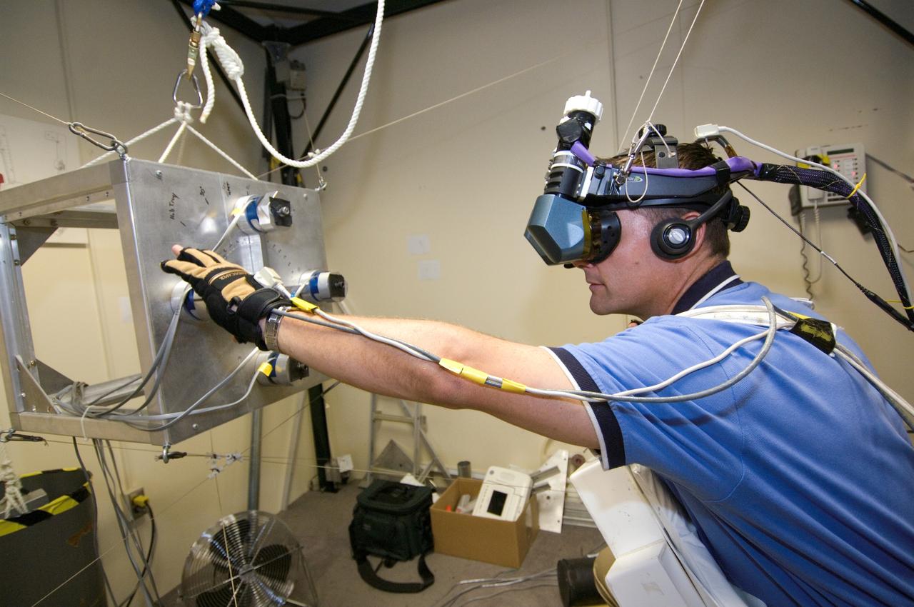 JSC2007-E-41537 (9 Aug. 2007) --- Astronaut Douglas H. Wheelock, STS-120 mission specialist, uses virtual reality hardware in the Space Vehicle Mockup Facility at Johnson Space Center to rehearse some of his duties on the upcoming mission to the International Space Station. This type of virtual reality training allows the astronauts to wear special gloves and other gear while looking at computer displays simulating actual movements around the various locations on the station hardware with which they will be working.