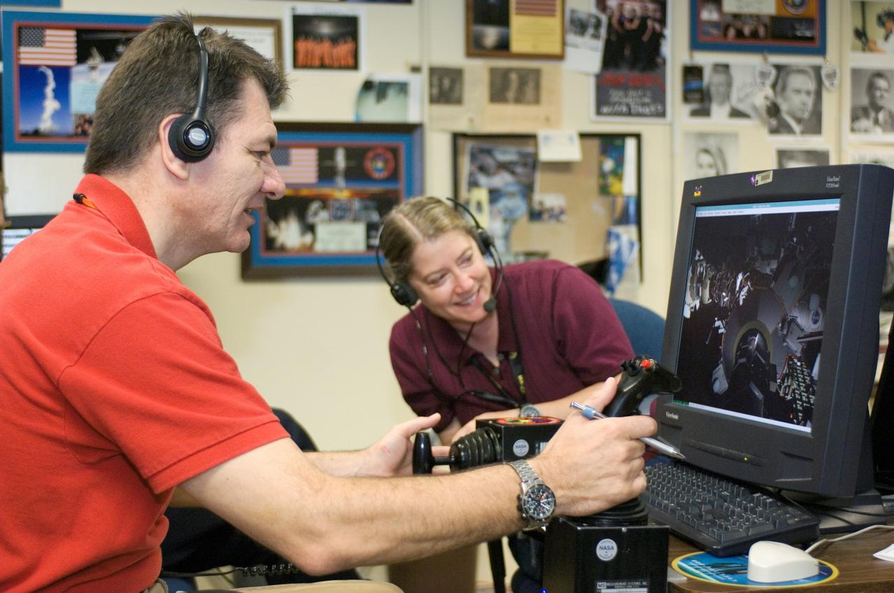 JSC2007-E-41540 (9 Aug. 2007) --- Astronauts Pamela A. Melroy, STS-120 commander, and European Space Agency's (ESA) Paolo Nespoli, mission specialist, use the virtual reality lab at Johnson Space Center to train for their duties aboard the space shuttle and space station. This type of computer interface, paired with virtual reality training hardware and software, helps to prepare the entire team for dealing with space station elements.