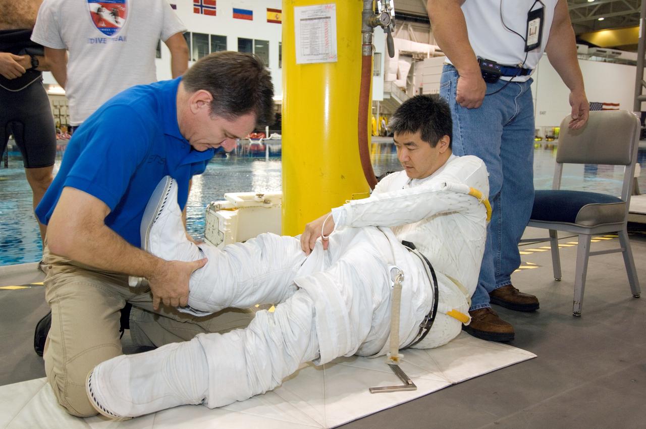 JSC2007-E-46530 (18 Sept. 2007) --- Astronaut Daniel M. Tani, Expedition 16 flight engineer, dons a training version of the Extravehicular Mobility Unit (EMU) spacesuit prior to being submerged in the waters of the Neutral Buoyancy Laboratory (NBL) near the Johnson Space Center. European Space Agency (ESA) astronaut Paolo Nespoli, STS-120 mission specialist, assisted Tani who is scheduled to join Expedition 16 after launching to the International Space Station on mission STS-120.