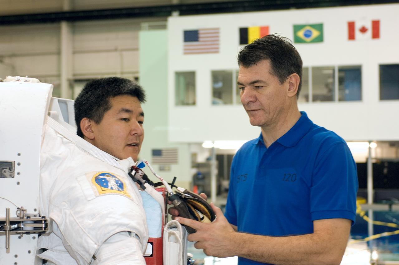 JSC2007-E-46535 (18 Sept. 2007) --- Astronaut Daniel M. Tani, Expedition 16 flight engineer, dons a training version of the Extravehicular Mobility Unit (EMU) spacesuit prior to being submerged in the waters of the Neutral Buoyancy Laboratory (NBL) near the Johnson Space Center. European Space Agency (ESA) astronaut Paolo Nespoli, STS-120 mission specialist, assisted Tani who is scheduled to join Expedition 16 after launching to the International Space Station on mission STS-120.