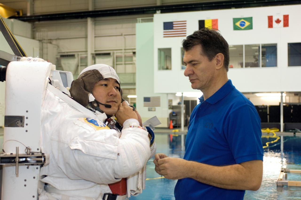 JSC2007-E-46540 (18 Sept. 2007) --- Astronaut Daniel M. Tani, Expedition 16 flight engineer, dons a training version of the Extravehicular Mobility Unit (EMU) spacesuit prior to being submerged in the waters of the Neutral Buoyancy Laboratory (NBL) near the Johnson Space Center. European Space Agency (ESA) astronaut Paolo Nespoli, STS-120 mission specialist, assisted Tani who is scheduled to join Expedition 16 after launching to the International Space Station on mission STS-120.