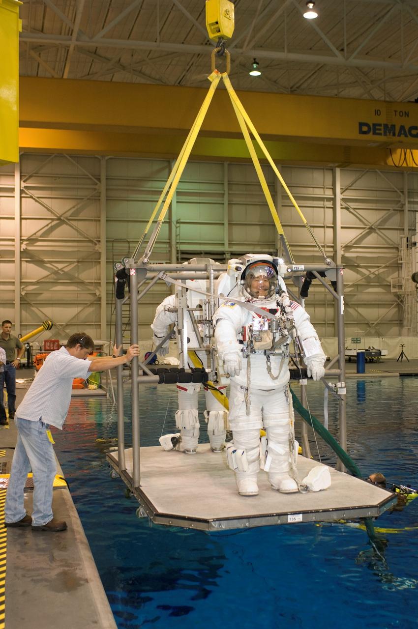 JSC2007-E-46551 (18 Sept. 2007) --- Astronauts Daniel M. Tani, Expedition 16 flight engineer; and Scott E. Parazynski (partially obscured), STS-120 mission specialist, are about to be submerged in the waters of the Neutral Buoyancy Laboratory (NBL) near Johnson Space Center. Tani and Parazynski are attired in training versions of their Extravehicular Mobility Unit (EMU) spacesuit. SCUBA-equipped divers (out of frame) are in the water to assist the crewmembers in their rehearsal, intended to help prepare them for work on the exterior of the International Space Station. Tani is scheduled to join Expedition 16 after launching to the station on mission STS-120.