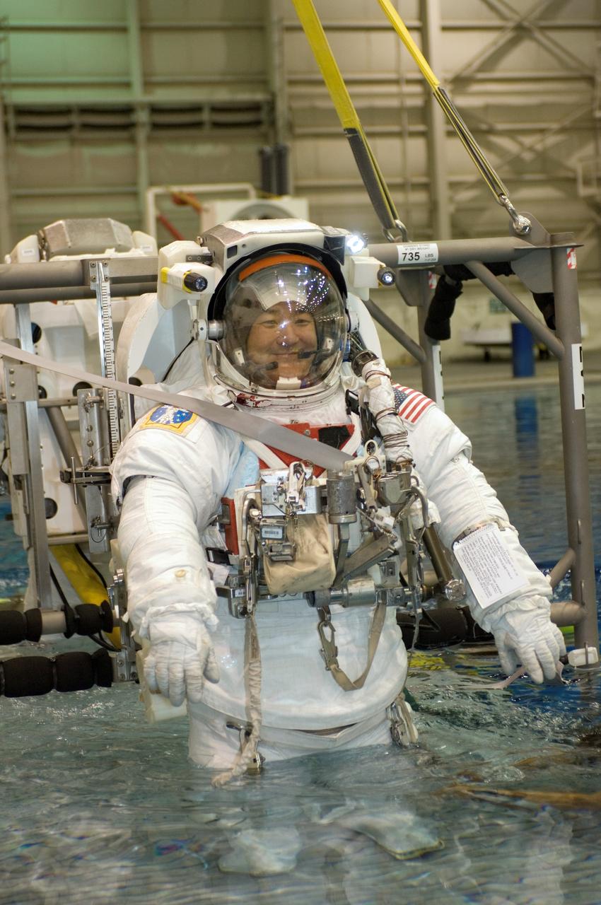 JSC2007-E-46552 (18 Sept. 2007) --- Astronauts Daniel M. Tani, Expedition 16 flight engineer; and Scott E. Parazynski (partially obscured), STS-120 mission specialist, are about to be submerged in the waters of the Neutral Buoyancy Laboratory (NBL) near Johnson Space Center. Tani and Parazynski are attired in training versions of their Extravehicular Mobility Unit (EMU) spacesuit. SCUBA-equipped divers (out of frame) are in the water to assist the crewmembers in their rehearsal, intended to help prepare them for work on the exterior of the International Space Station. Tani is scheduled to join Expedition 16 after launching to the station on mission STS-120.