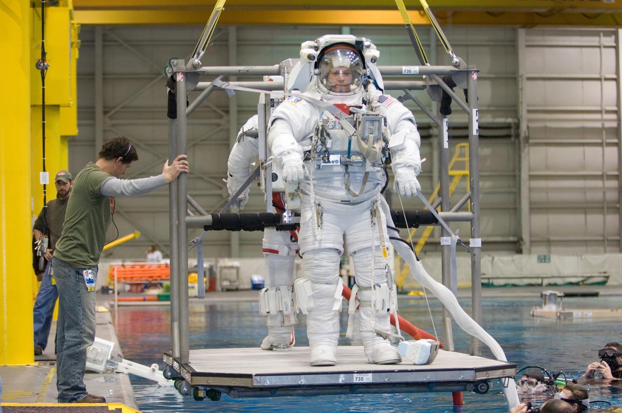 JSC2007-E-06548 (2 Feb. 2007) --- Astronauts Douglas H. Wheelock and Scott E. Parazynski (partially obscured), both STS-120 mission specialists, are about to be submerged in the waters of the Neutral Buoyancy Laboratory (NBL) near Johnson Space Center. Wheelock and Parazynski are attired in training versions of the Extravehicular Mobility Unit (EMU) spacesuit. SCUBA-equipped divers are in the water to assist the crewmembers in their rehearsal, intended to help prepare them for work on the exterior of the International Space Station.