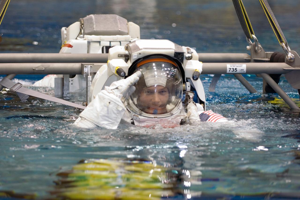 JSC2007-E-06550 (2 Feb. 2007) --- Astronauts Douglas H. Wheelock and Scott E. Parazynski (partially obscured), both STS-120 mission specialists, are about to be submerged in the waters of the Neutral Buoyancy Laboratory (NBL) near Johnson Space Center. Wheelock and Parazynski are attired in training versions of the Extravehicular Mobility Unit (EMU) spacesuit. SCUBA-equipped divers (out of frame) are in the water to assist the crewmembers in their rehearsal, intended to help prepare them for work on the exterior of the International Space Station.