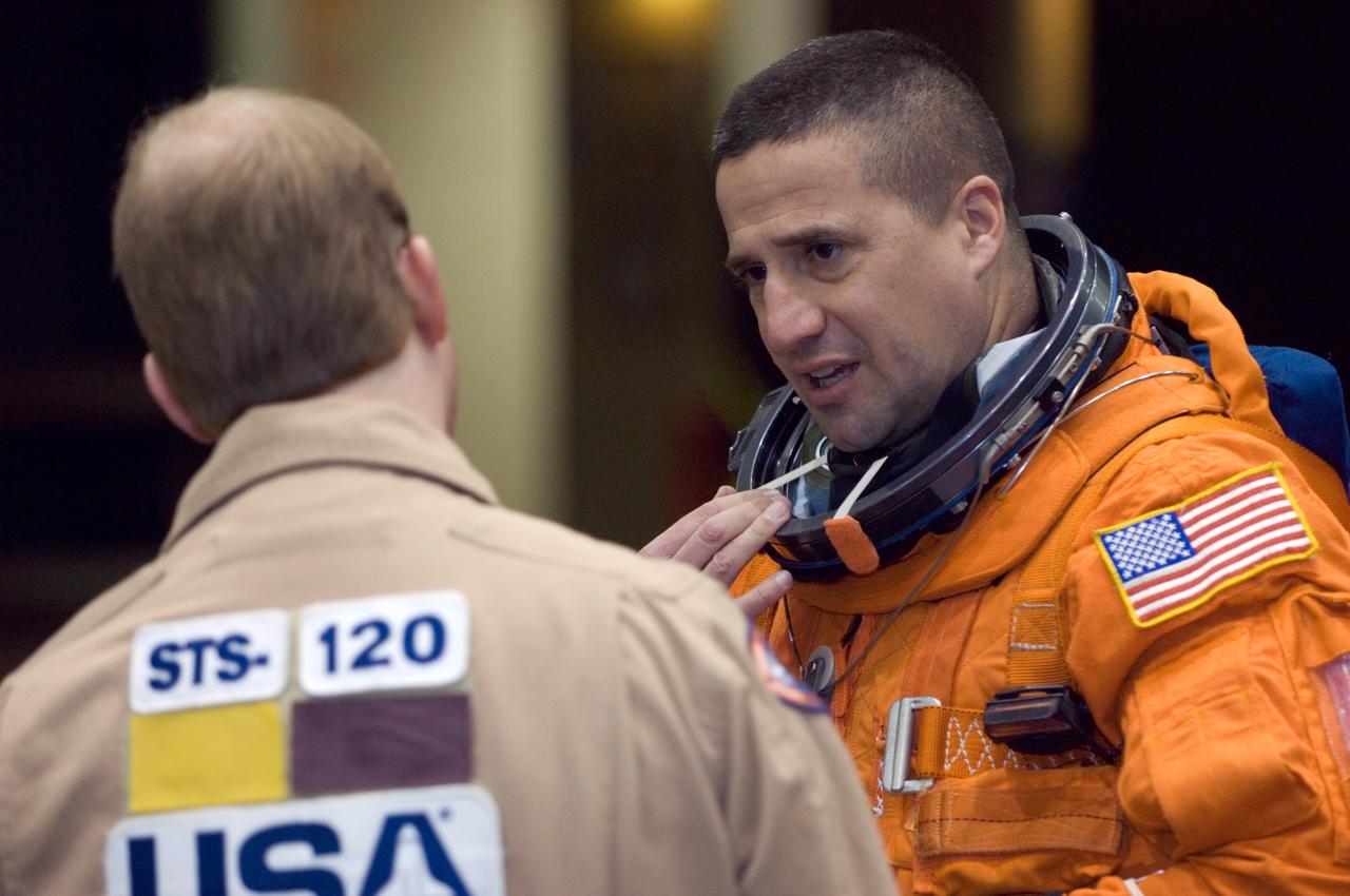 JSC2007-E-08822 (7 Feb. 2007) --- Attired in a training version of his shuttle launch and entry suit, astronaut George D. Zamka, STS-120 pilot, and United Space Alliance (USA) suit technician Daniel E. Palmer (back to camera) exchange thoughts prior to the start of a post insertion/de-orbit training session in one of the full-scale trainers (out of frame) in the Space Vehicle Mockup Facility at Johnson Space Center.