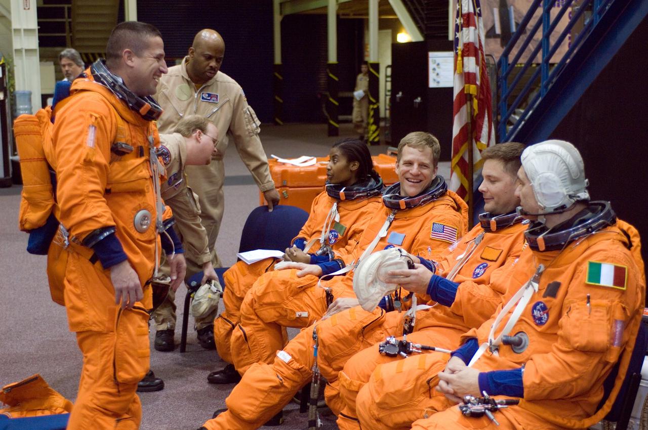 JSC2007-E-08823 (7 Feb. 2007) --- Attired in training versions of their shuttle launch and entry suit, STS-120 crewmembers enjoy a light moment as they await the start of a post insertion/de-orbit training session in one of the full-scale trainers (out of frame) in the Space Vehicle Mockup Facility at Johnson Space Center. Pictured are astronauts George D. Zamka (standing), pilot; Stephanie D. Wilson (seated, left), Scott E. Parazynski, Douglas H. Wheelock and European Space Agency's (ESA) Paolo Nespoli, all mission specialists. Also pictured (background) are United Space Alliance (USA) suit technicians Daniel E. Palmer and Andre Denard.
