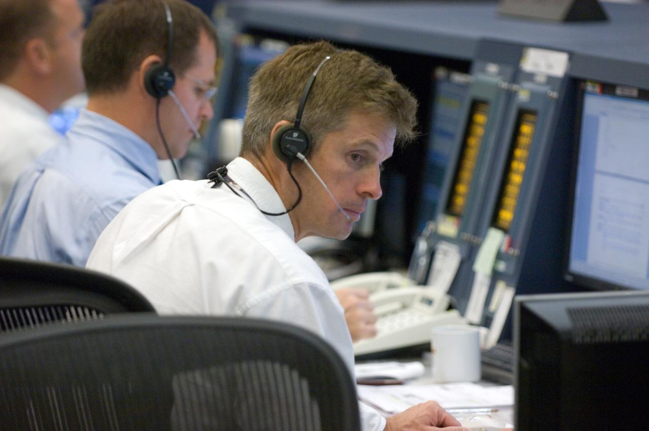 JSC2007-E-093444 (3 Nov. 2007) ---Astronauts Steve Swanson (foreground) and Kevin Ford, at the spacecraft communicator (CAPCOM) console in the space station control room of JSC's Mission Control Center, communicate with astronauts in space during the Nov. 3 spacewalk planned to repair a tear in a solar panel on the International Space Station.