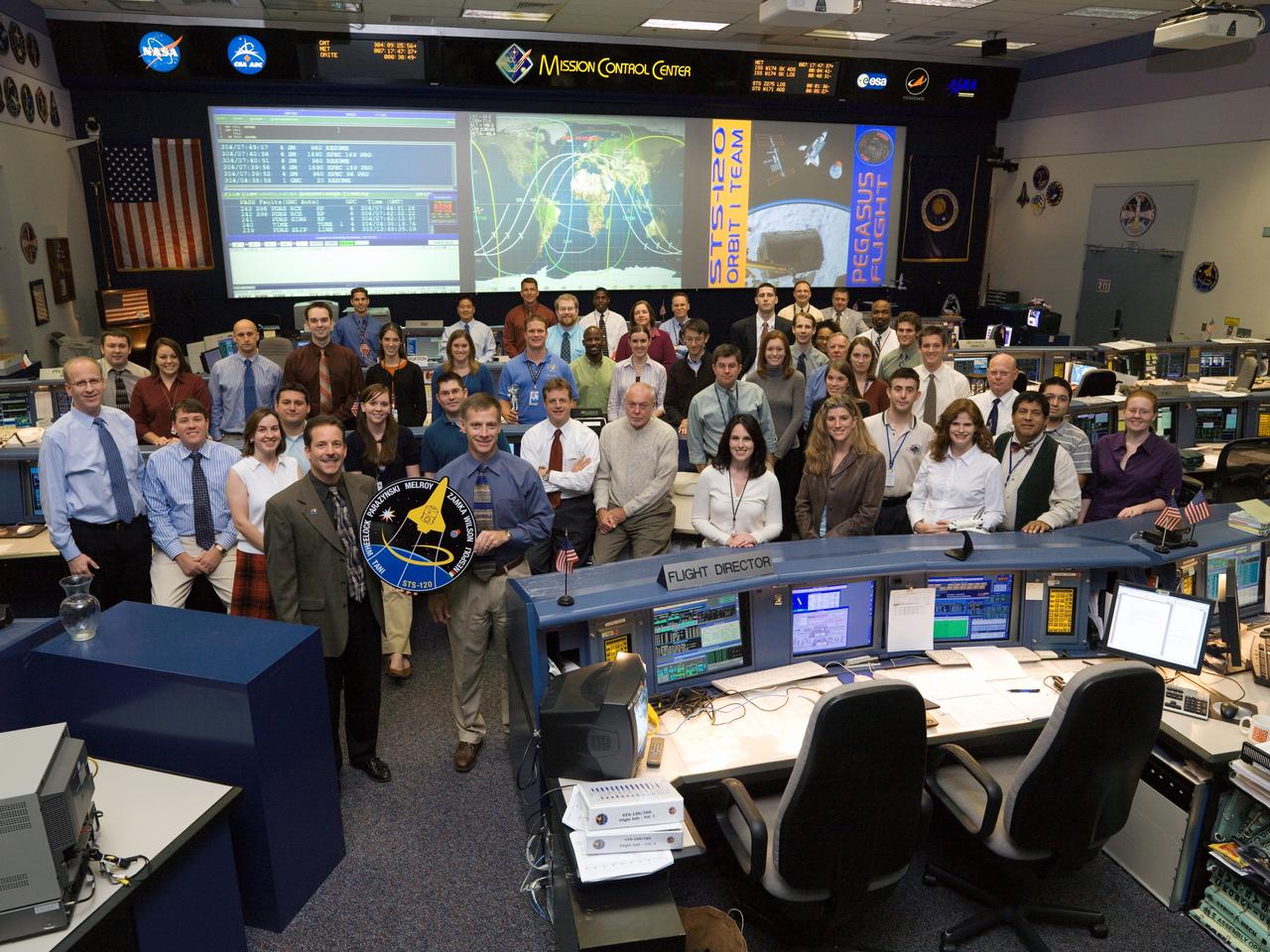 JSC2007-E-095034 (31 Oct. 2007) --- The members of the STS-120 Orbit 1 flight control team pose for a portrait in the space shuttle flight control room in Houston's Mission Control Center (MCC). Flight director Rick LaBrode (left) and astronaut Chris Ferguson, spacecraft communicator (CAPCOM), hold the STS-120 mission logo.
