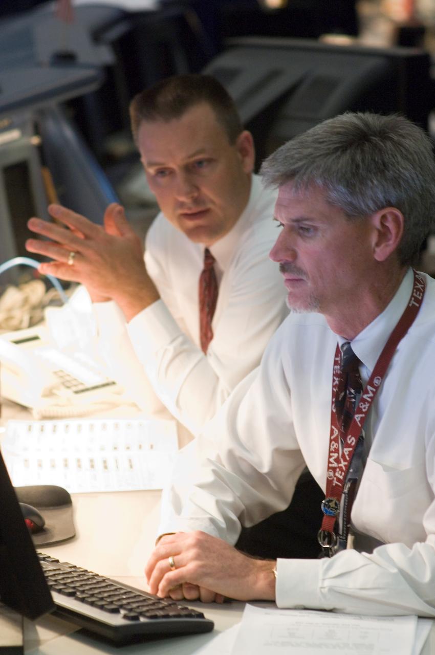 JSC2007-E-095788 (3 Nov. 2007) --- Flight directors Norm Knight (left) and Bryan Lunney, inside the shuttle flight control room of JSC's Mission Control Center, monitor the progress of the Nov. 3 spacewalk by two members of Discovery's crew, while the space shuttle is docked with the International Space Station in Earth orbit.   Astronaut Scott Parazynski was busy at work on repairing a tear in a solar panel on the orbiting outpost.