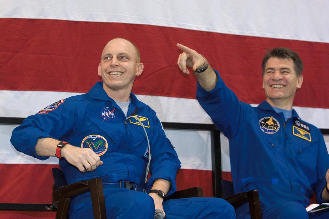 JSC2007-E-098010 (8 Nov. 2007) --- "Look, I'm seeing double," European Space Agency astronaut Paolo Nespoli appears to be saying as he points toward a life size photo cutout (out of frame) of astronaut Clay Anderson, seated to his right, during the Discovery crew's Nov. 8 welcome home ceremony at Houston's Ellington Field.  The two mission specialists were joined by their five STS-120 crewmates on the stage of Ellington's hangars.