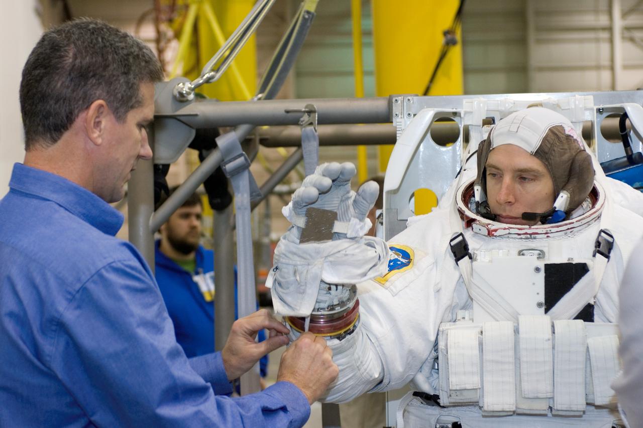 JSC2007-E-113486 (17 Dec. 2007) --- Astronaut Andrew J. Feustel, STS-125 mission specialist, dons a training version of the Extravehicular Mobility Unit (EMU) spacesuit prior to being submerged in the waters of the Neutral Buoyancy Laboratory (NBL) near the Johnson Space Center. Astronaut Michael T. Good, mission specialist, assisted Feustel.