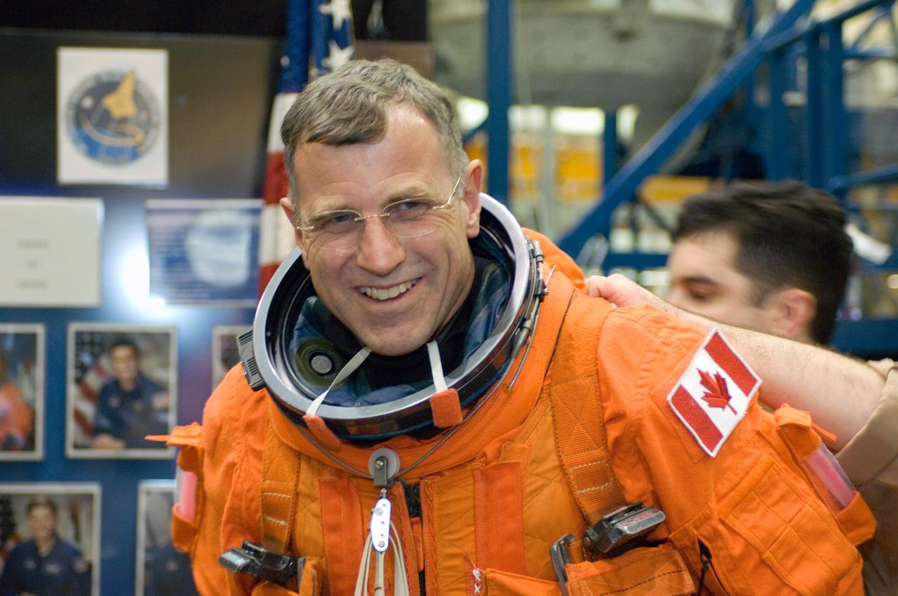JSC2007-E-15872 (22 March 2007) --- Canadian Space Agency astronaut Dafydd R. (Dave) Williams, STS-118 mission specialist, receives assistance in donning a training version of his shuttle launch and entry suit in preparation for a training session in the Full Fuselage Trainer (FFT) mockup (out of frame) in the Space Vehicle Mockup Facility at the Johnson Space Center.