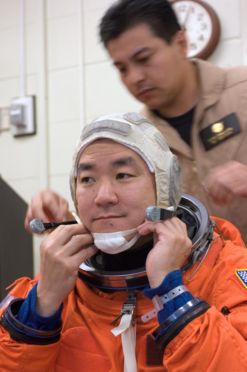 JSC2007-E-18063 (9 April 2007) --- Astronaut Daniel M. Tani, Expedition 16 flight engineer, dons a training version of his shuttle launch and entry suit in preparation for a training session in the Space Vehicle Mockup Facility at the Johnson Space Center. Tani is scheduled to join Expedition 16 as flight engineer after launching to the International Space Station on mission STS-120 and is scheduled to return home on mission STS-122. United Space Alliance suit technician Ryan Carabaja assisted Tani.