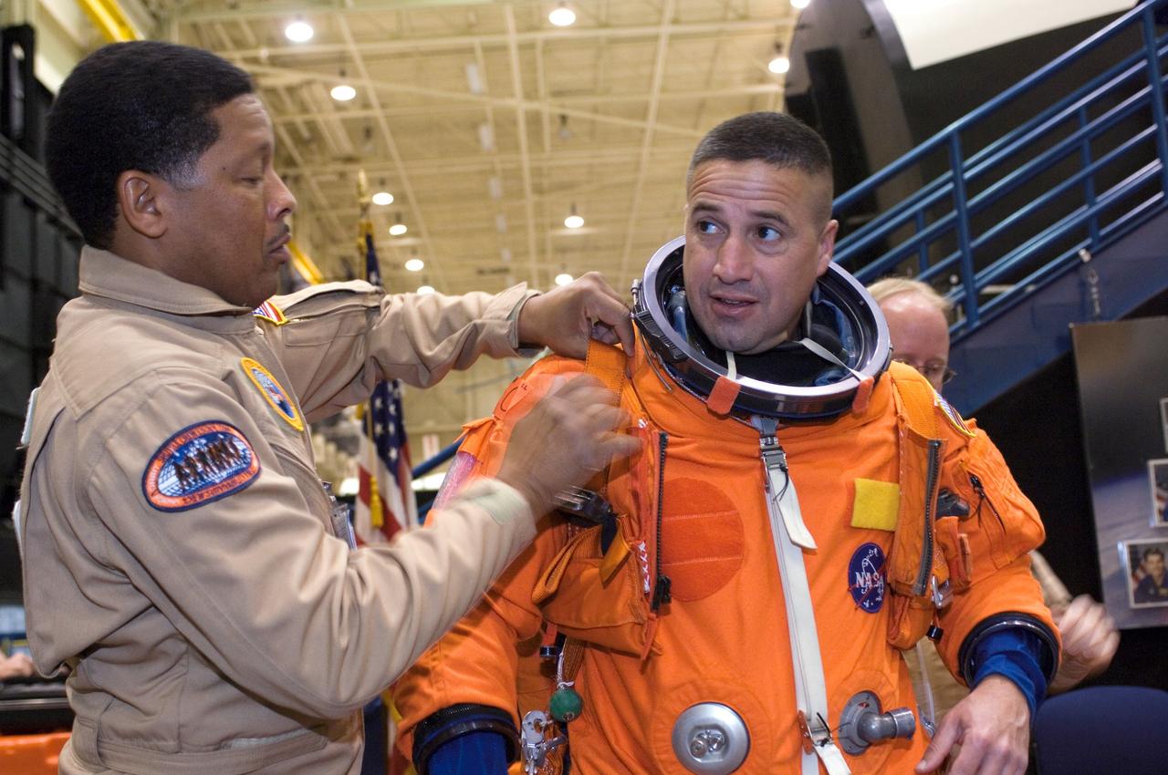 JSC2007-E-18064 (9 April 2007) --- Astronaut George D. Zamka, STS-120 pilot, dons a training version of his shuttle launch and entry suit in preparation for a training session in the Space Vehicle Mockup Facility at the Johnson Space Center. United Space Alliance suit technicians George Brittingham (left) and Daniel Palmer (partially obscured) assisted Zamka.