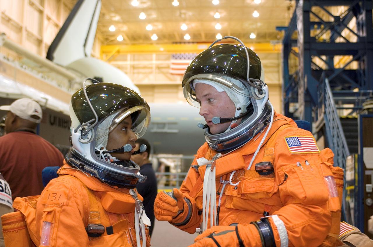 JSC2007-E-18080 (9 April 2007) --- Attired in training versions of their shuttle launch and entry suits, astronauts Stephanie D. Wilson (left) and Douglas H. Wheelock, both STS-120 mission specialists, exchange thoughts as they participate in a training session in the Space Vehicle Mockup Facility at Johnson Space Center.