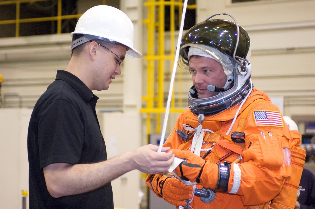 JSC2007-E-18102 (9 April 2007) --- United Space Alliance (USA) crew trainer Adam Flagan (left) briefs astronaut Douglas H. Wheelock, STS-120 mission specialist, on the usage of a special pulley device, used to lower oneself from a trouble-plagued shuttle. The briefing came during an emergency egress training session in the Space Vehicle Mockup Facility at the Johnson Space Center. Wheelock is wearing a training version of his shuttle launch and entry suit.
