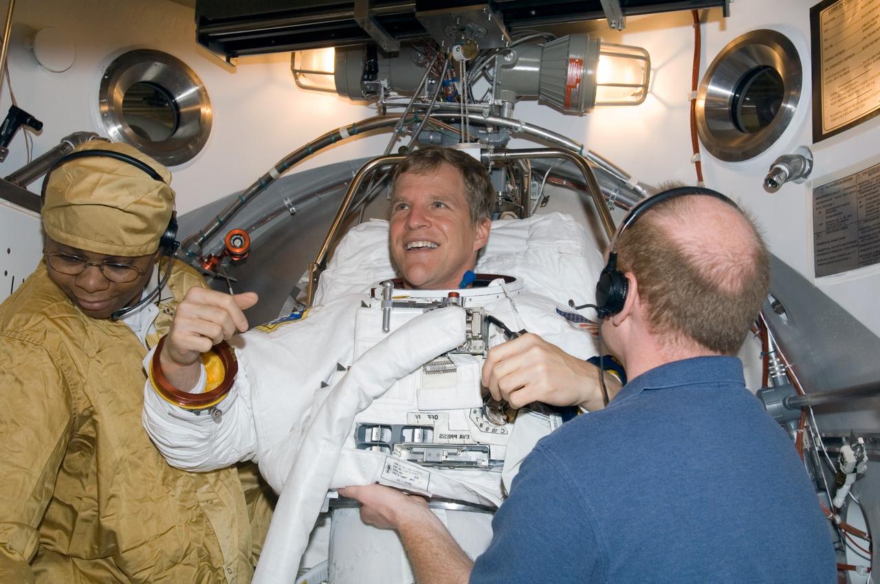 JSC2007-E-18450 (5 April 2007) --- Astronaut Scott E. Parazynski, STS-120 mission specialist, participates in an Extravehicular Mobility Unit (EMU) spacesuit fit check in the Space Station Airlock Test Article (SSATA) in the Crew Systems Laboratory at the Johnson Space Center. United Space Alliance (USA) suit technician James Lemmon (left) and USA suit engineer Shawn Macleod assisted Parazynski.
