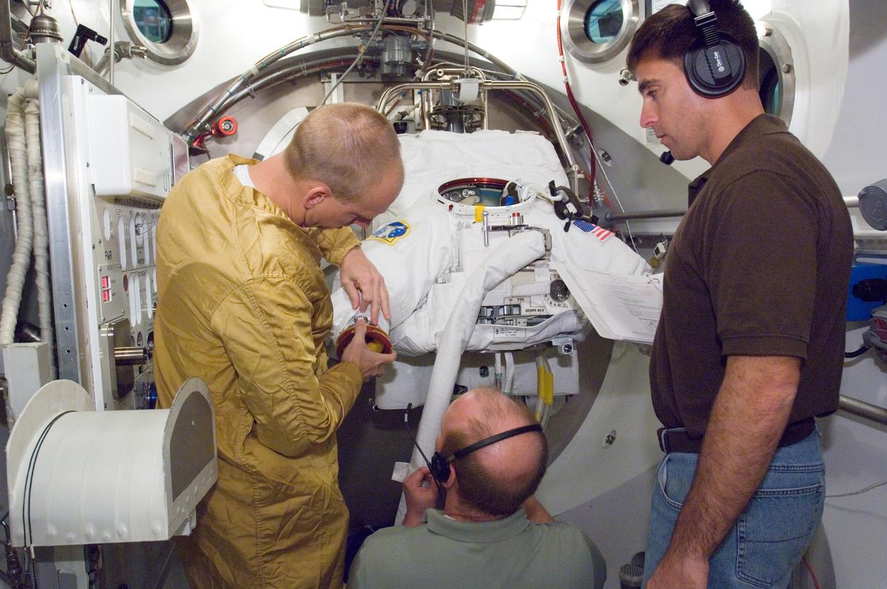 JSC2007-E-19292 (18 April 2007) --- Astronaut Clayton C. Anderson (left), Expedition 15 flight engineer, participates in an Extravehicular Mobility Unit (EMU) spacesuit fit check in the Space Station Airlock Test Article (SSATA) in the Crew Systems Laboratory at Johnson Space Center. Astronaut Christopher J. Cassidy (right) and USA suit engineer Shawn Macleod assisted Anderson, who will join Expedition 15 as flight engineer after launching to the International Space Station aboard Space Shuttle Atlantis on mission STS-117.