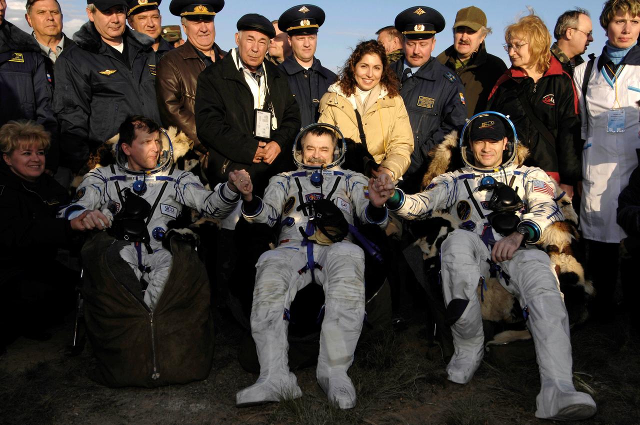 JSC2007-E-19320 (21 April 2007) --- From the left, U.S. spaceflight participant Charles Simonyi; cosmonaut Mikhail Tyurin, Expedition 14 Flight Engineer and Soyuz commander; and astronaut Michael E. Lopez-Alegria, Expedition 14 commander and NASA ISS science officer, sit in chairs near their Soyuz TMA-9 spacecraft at their landing site. Landing and recovery officials were conducting post-landing medical checks on the three crewmembers. The Soyuz spacecraft landed southwest of Karaganda, Kazakhstan at approximately 6:30 pm local time, April 21, 2007. Photo Credit: NASA/Bill Ingalls